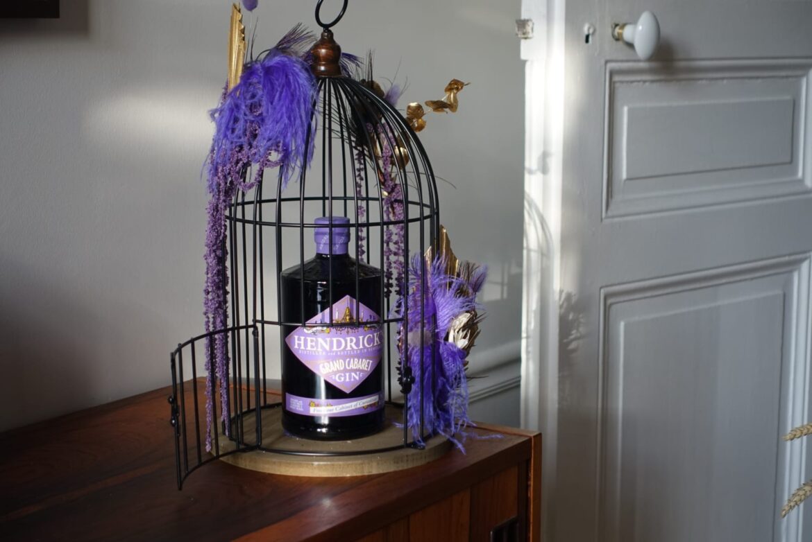 LE CABINET DE CURIOSITÉS Niché au cœur de l’Ecosse, le Gin Palace renferme un cabinet verrouillé où Lesley Gracie, Maître Distillatrice réputée d’Hendrick’s Gin, conserve ses créations les plus audacieuses. Ses élixirs, distillées à partir de plantes soigneusement cultivées dans les serres de la distillerie et agrémentés de trouvailles ramenées de ses voyages à travers le monde ou offertes par des visiteurs, incarnent l’essence de l’expérimentation botanique. Chaque année, l’une de ses créations est extraite de ce cabinet pour être partagée avec le monde entier. Le Cabinet de Curiosités a débuté avec Hendrick’s Midsummer Solstice, une première édition aux nuances florales, évoquant la splendeur du solstice d’été. Puis Hendrick’s Lunar Gin a capturé l’imaginaire avec son flacon d’un bleu intense et ses notes chaleureuses évoquant la magie nocturne. Le troisième, Hendrick’s Neptunia Gin, a offert une fraîcheur semblable à celle d’une brise marine. Hendrick’s Flora Adora, quatrième édition, a plongé les sens dans un jardin féérique.Aujourd’hui, Hendrick’s dévoile sa cinquième édition, Grand Cabaret, une expérience sensorielle où la poésie des arômes se mêle à l’esprit de renouveau.